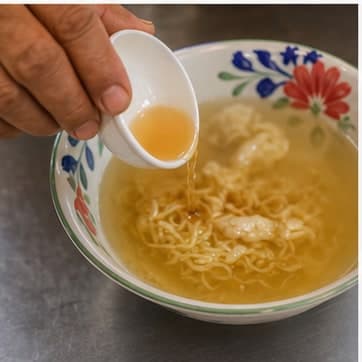 调味AI 拟真教学图：真实烹饪过程照片：必须表现“调味”。画面应对应动作：加入鱼露、糖、酱汁；鱼露和盐类先加 80%。；加入材料：鱼露、棕榈糖；视觉标准：咸鲜和甜味开始融合。