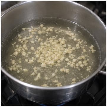 爆香基础香料AI 拟真教学图：真实烹饪过程照片：必须表现“爆香基础香料”。画面应对应动作：加入蒜、香茅、咖喱酱或红葱头，炒/煮到香气释放。；加入材料：蒜；视觉标准：香味明显，颜色略变深。