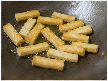 煎豆腐AI 拟真教学图:真实烹饪过程照片:必须表现“煎豆腐”。画面应对应动作:大火热锅,加 15g 油,煎豆腐到边缘微黄,盛出。;加入材料:硬豆腐、植物油;视觉标准:豆腐边缘金黄但内部仍软。